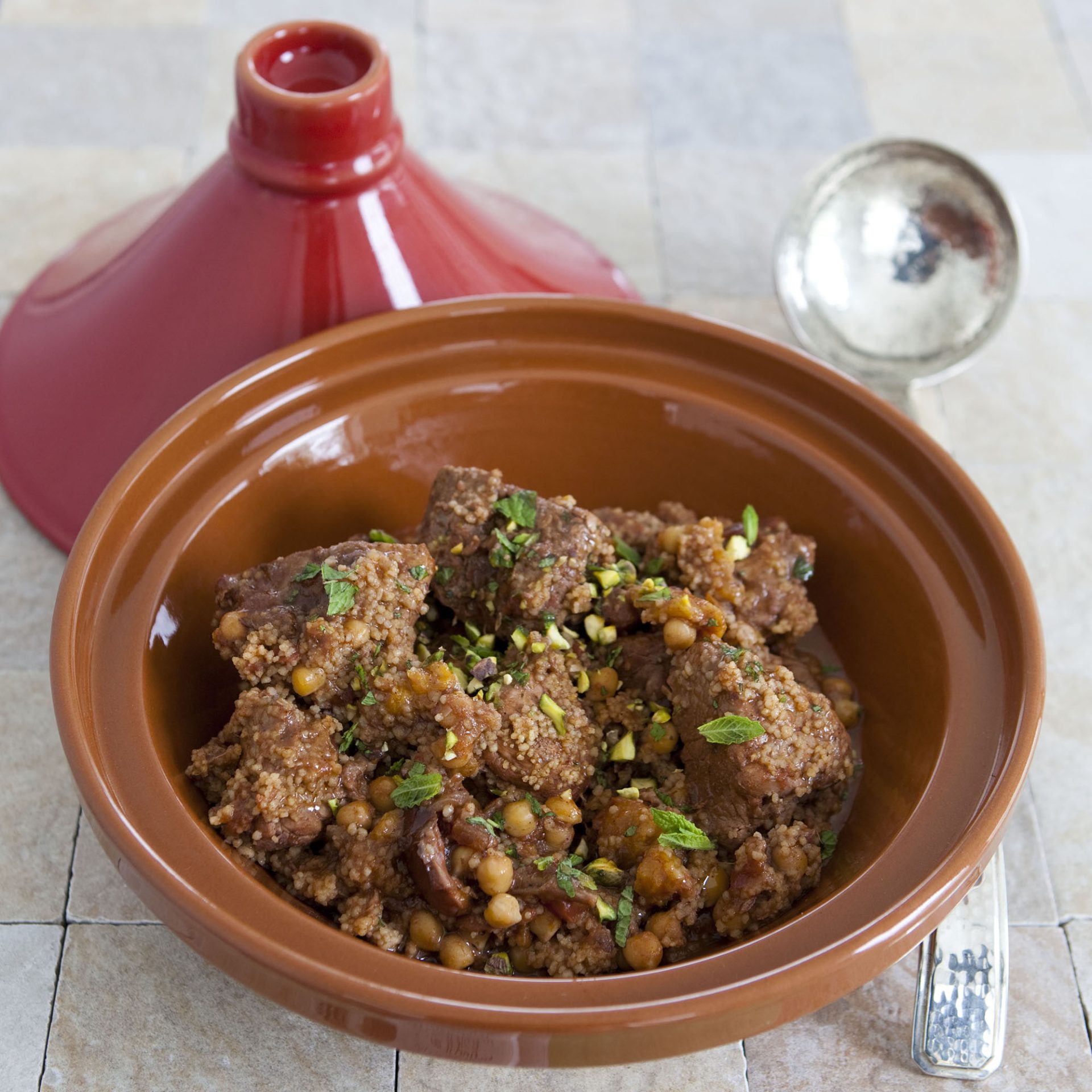 Brown tagine pot with lid off, with pork tagine displayed.