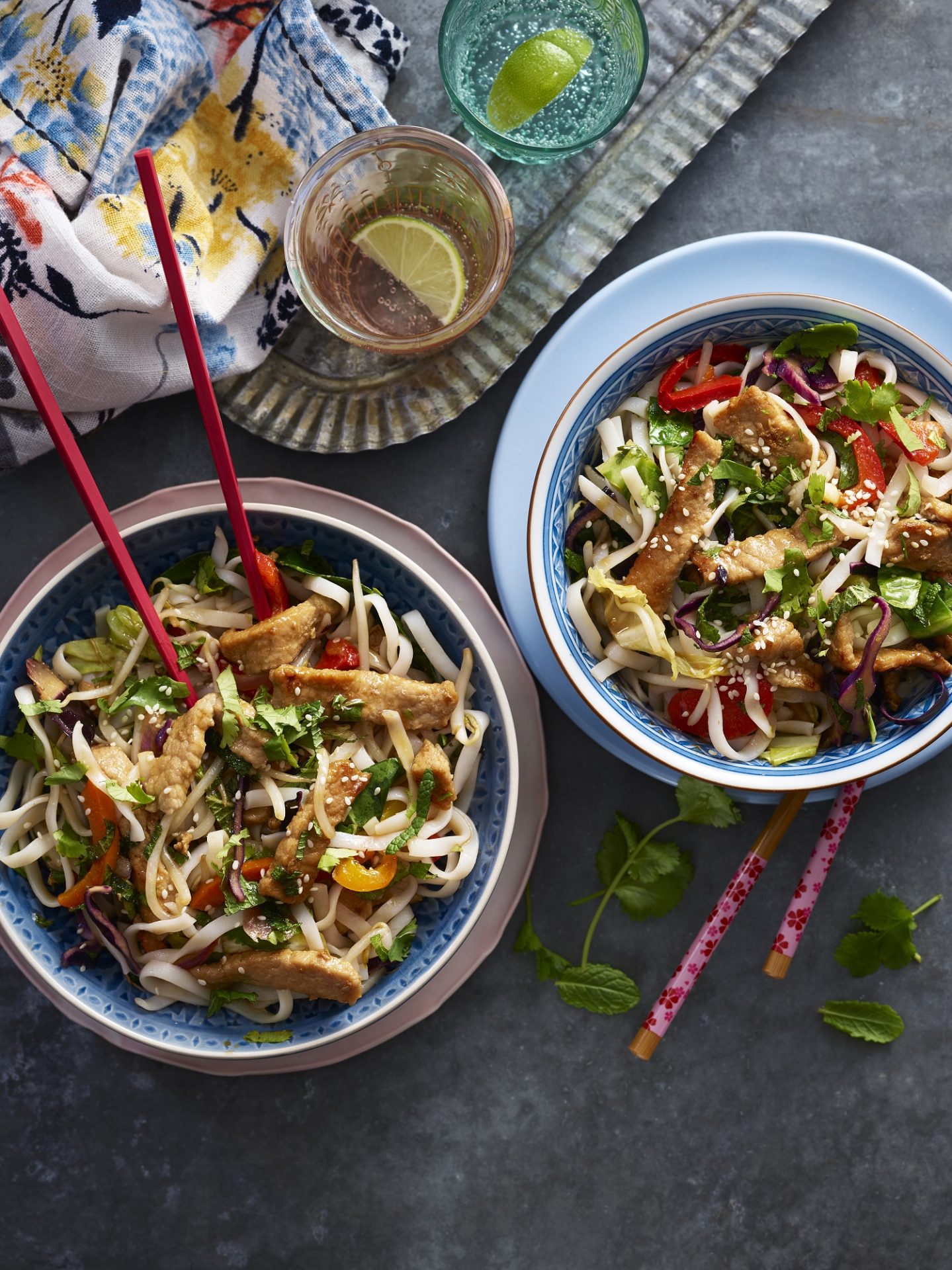 Two bowls with chopsticks containing sticky pork noodle dish