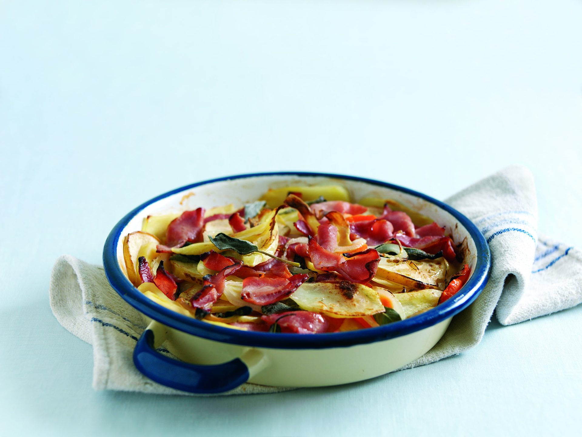 White and blue dish with bacon hotpot, on a white table cloth