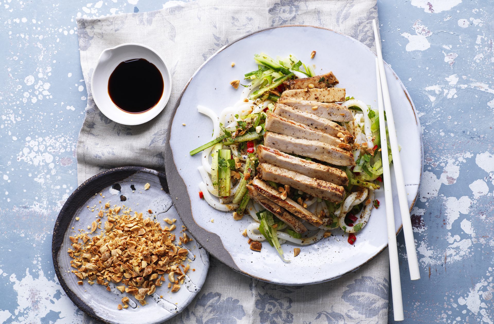 Sliced five spice pork with noodles on a plate with chopsticks