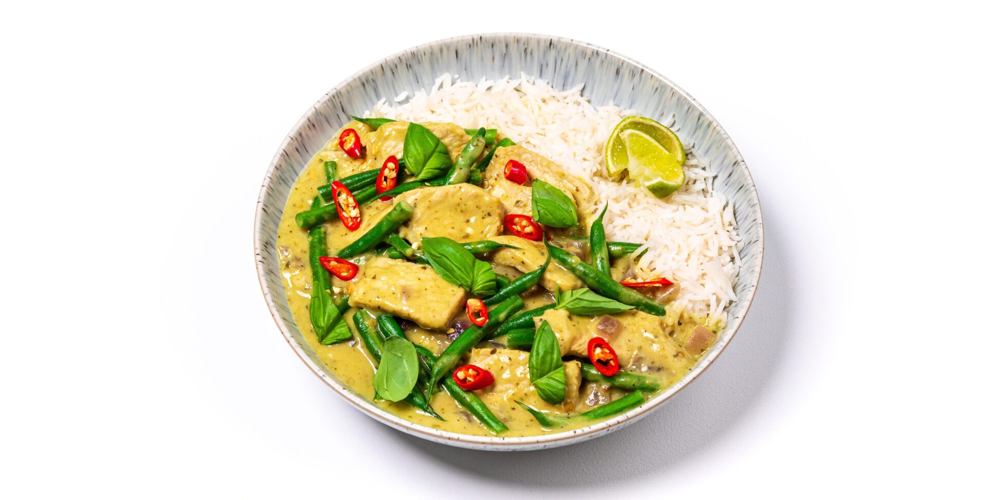 Thai green pork curry with rice in a white bowl