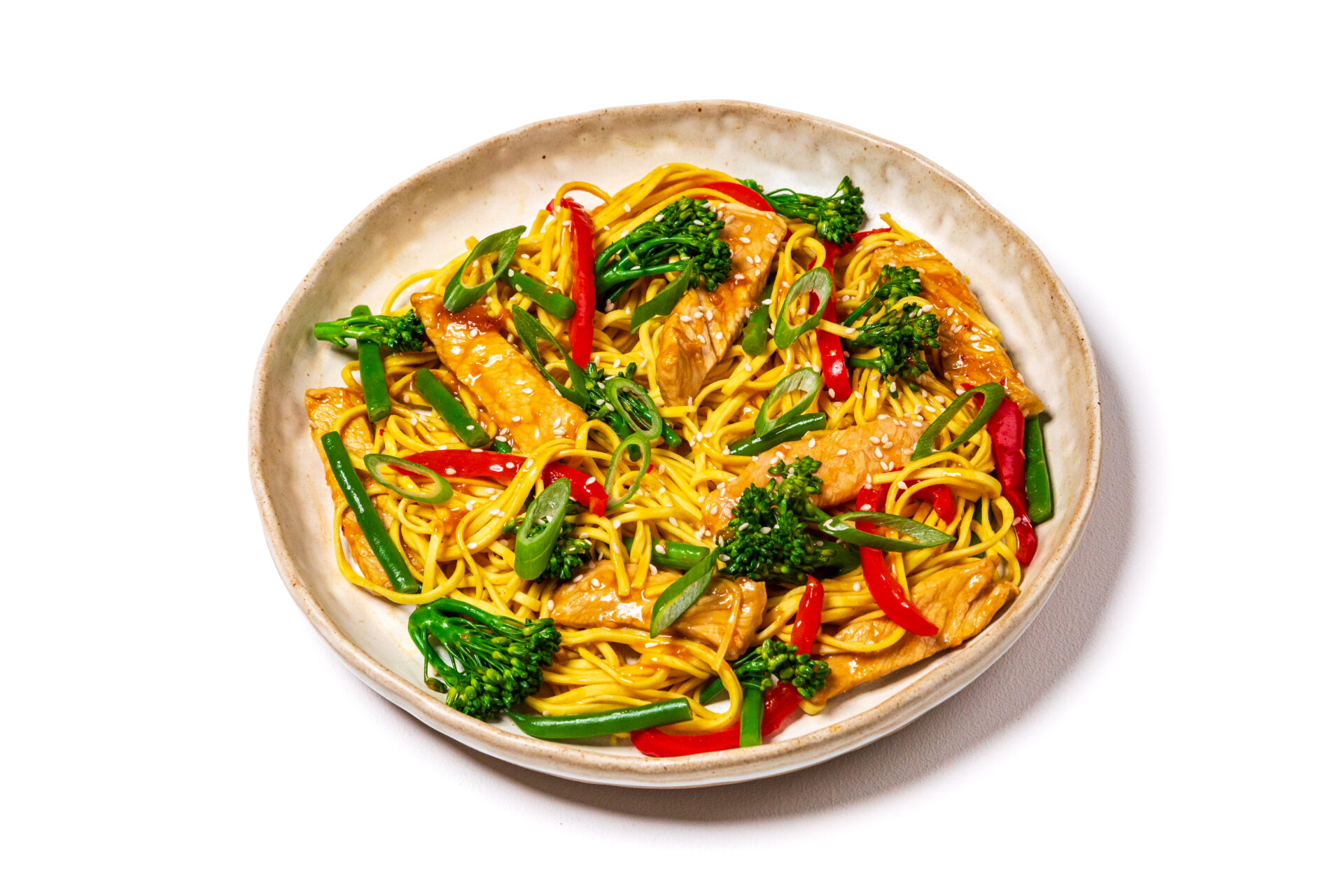 Pork and ginger stir fry with vegetables on a white plate