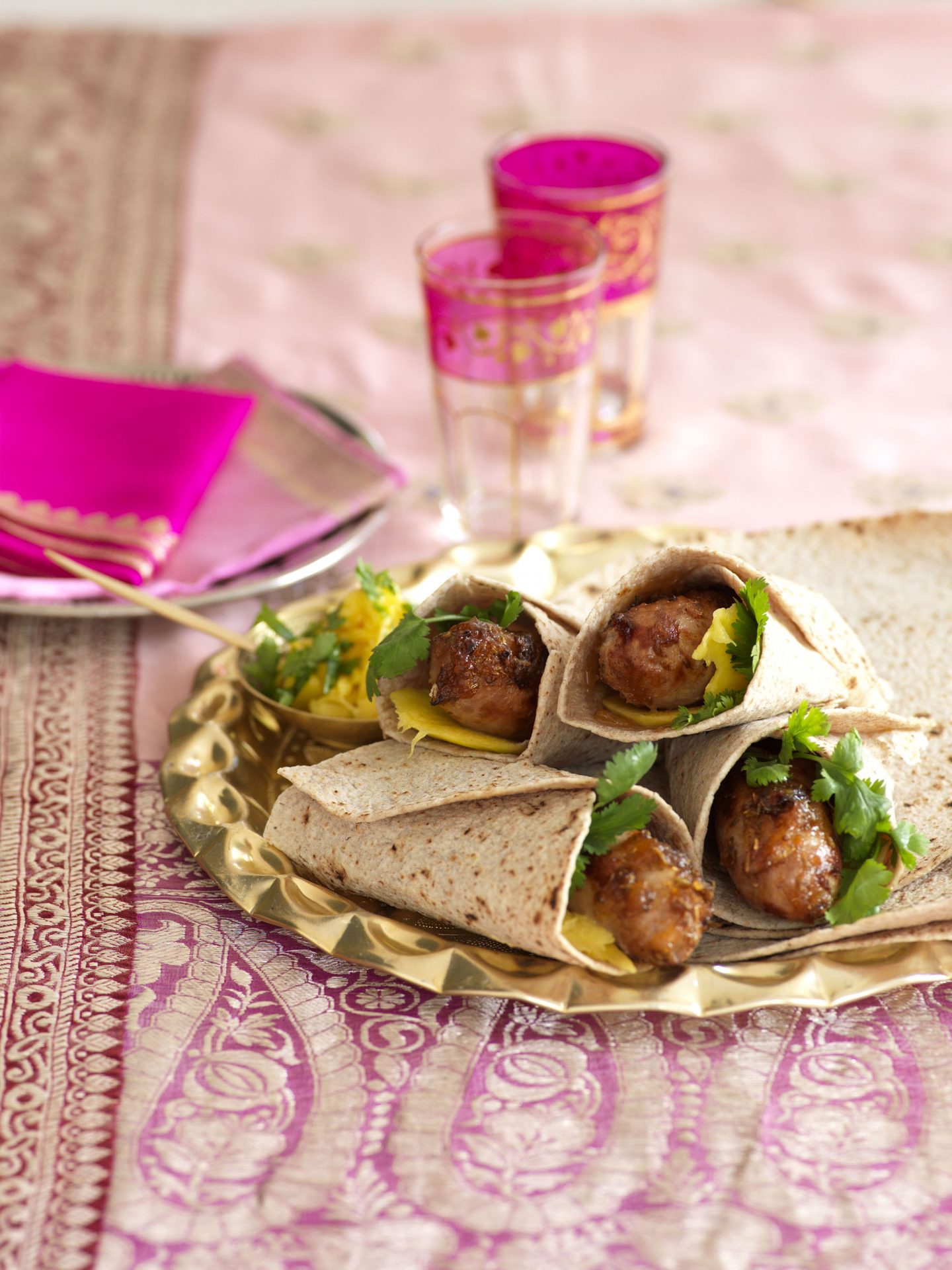 Sausages in tortilla wraps with salad on a plate