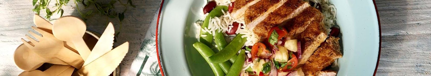 Pork medallions with vegetables served on a white plate