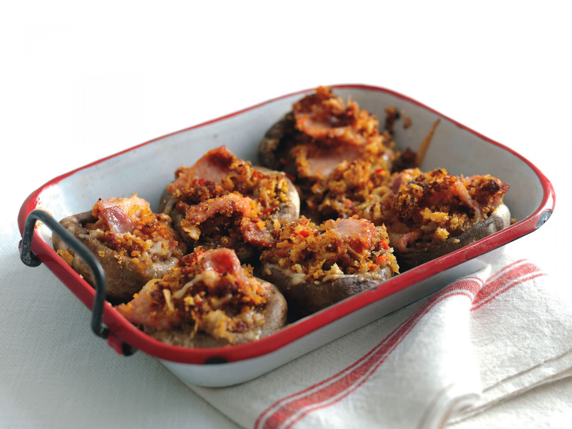 Six crunchy topped backed mushrooms in a baking dish