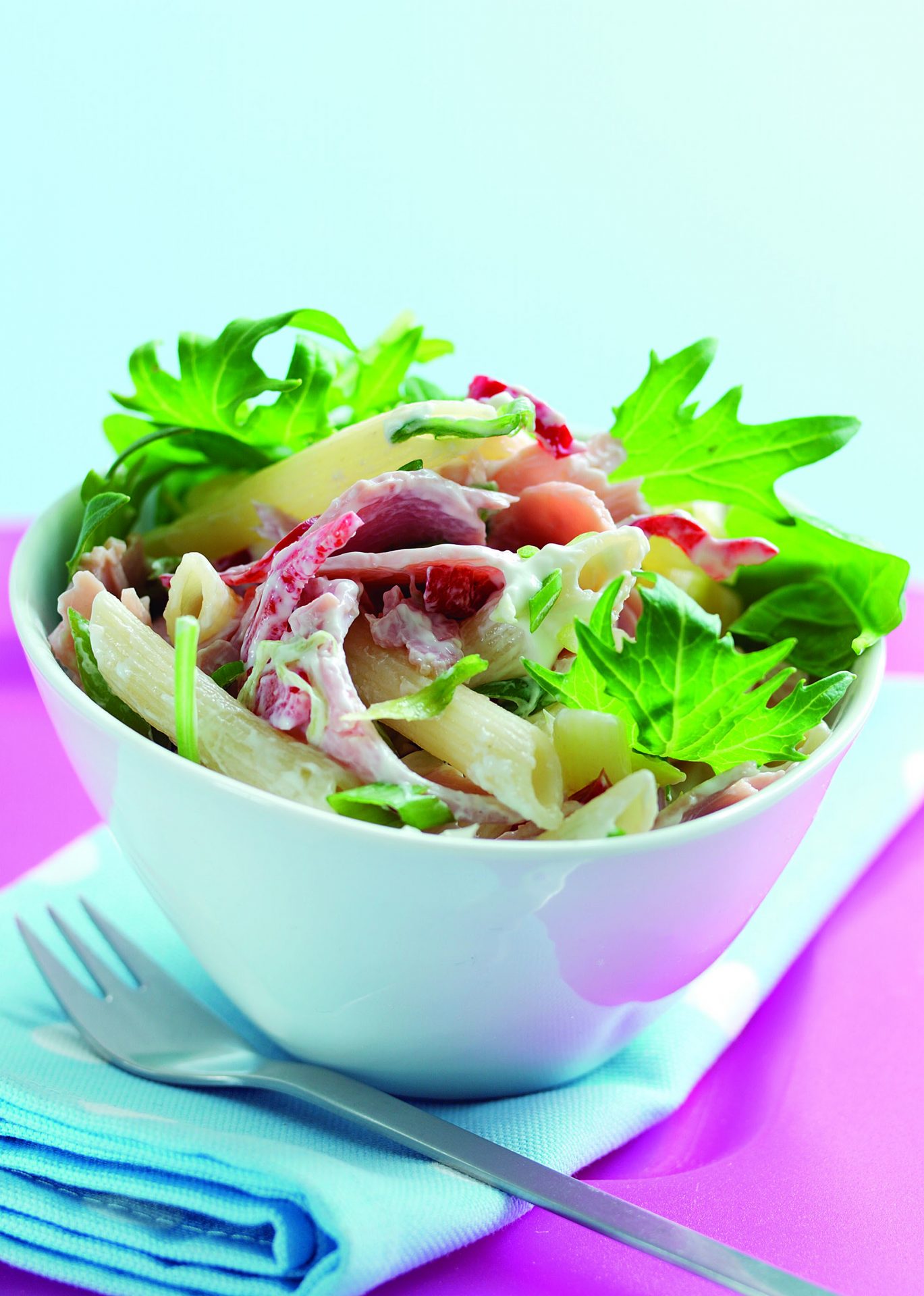 Sliced gammon with chilli and coriander potato salad in a small white bowl