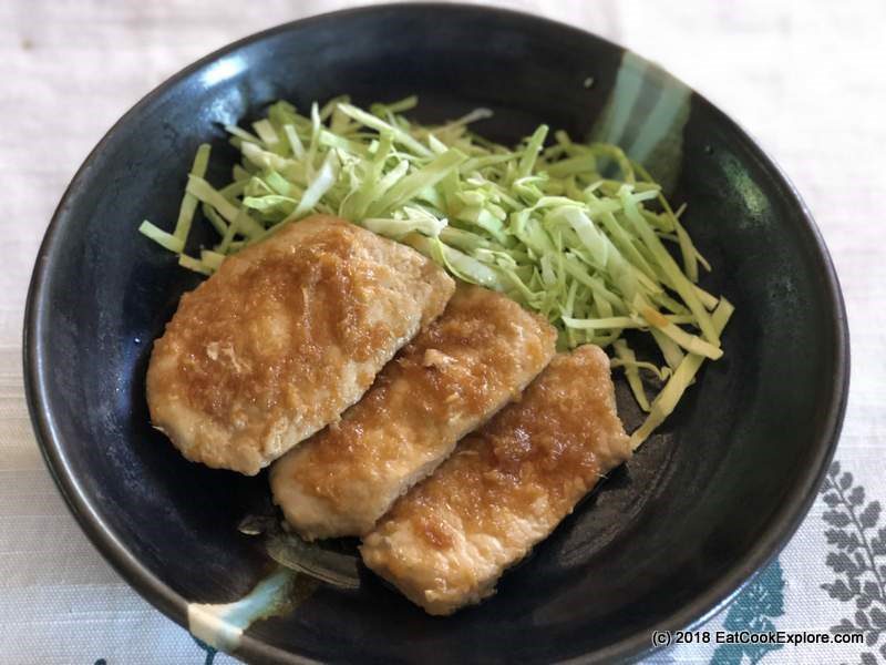 Three pieces of pork shogayaki in a black bowl