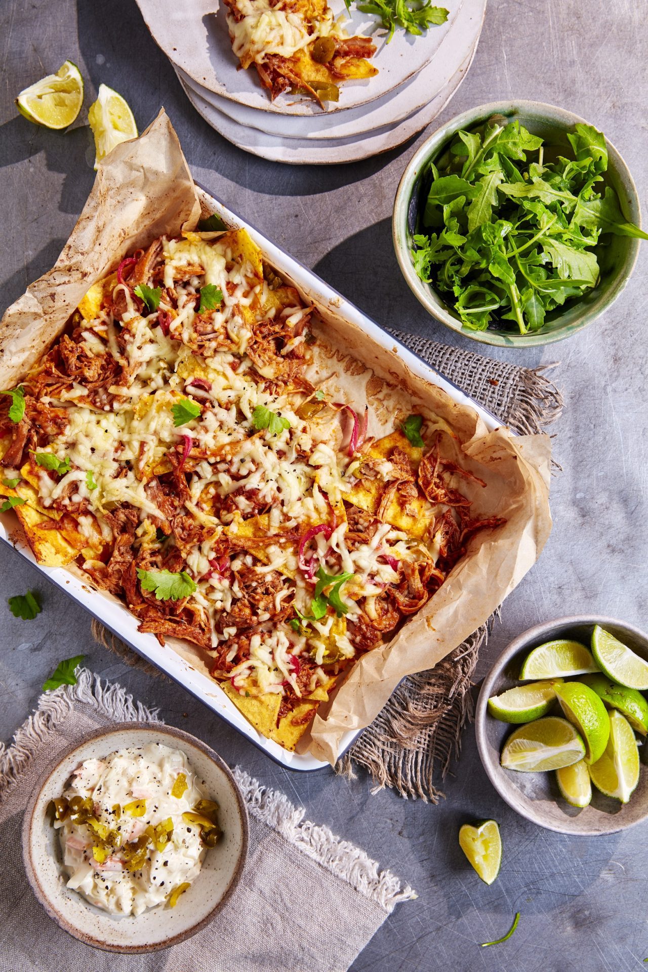 Pulled pork topped nachos with cheese served in a baking tray