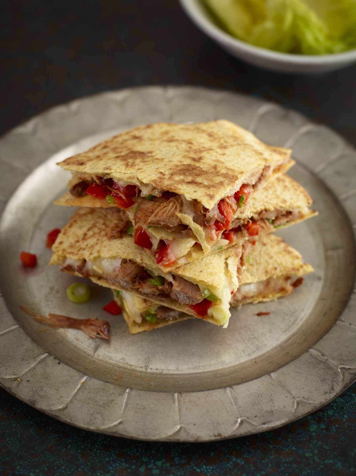 Pulled pork quesadillas in quarters, served on a plate