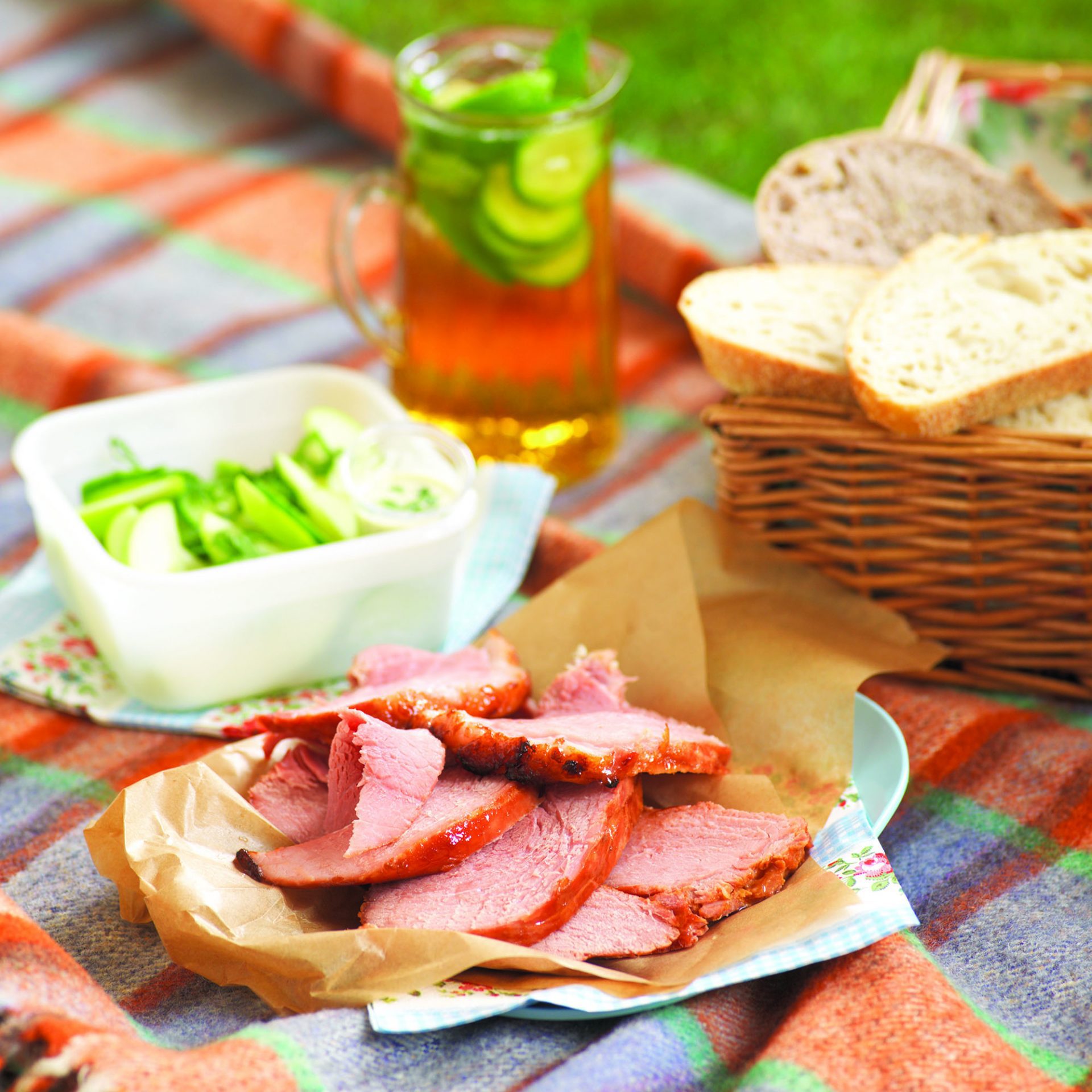 Sliced gammon on a plate, with picnic blanket set up