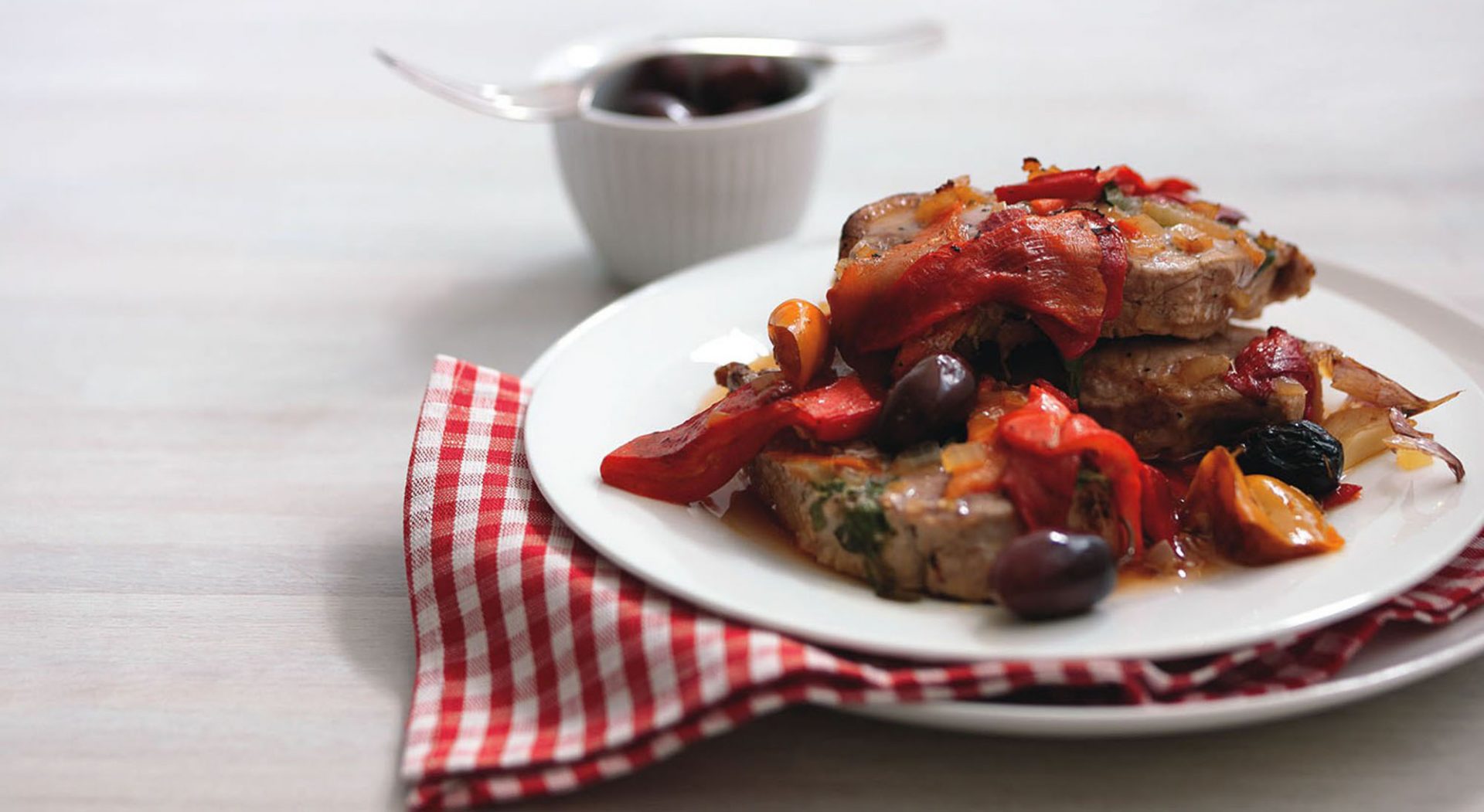 Baked pork steaks with vegetables served on a white plate