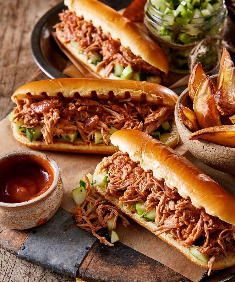 Hot dog buns filled with pulled pork and cucumber salsa