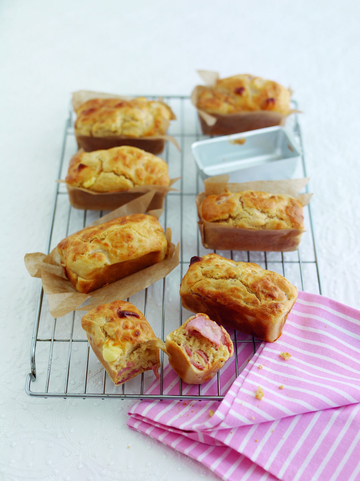 Six mini bacon ploughmans loaves on a wire baking rack