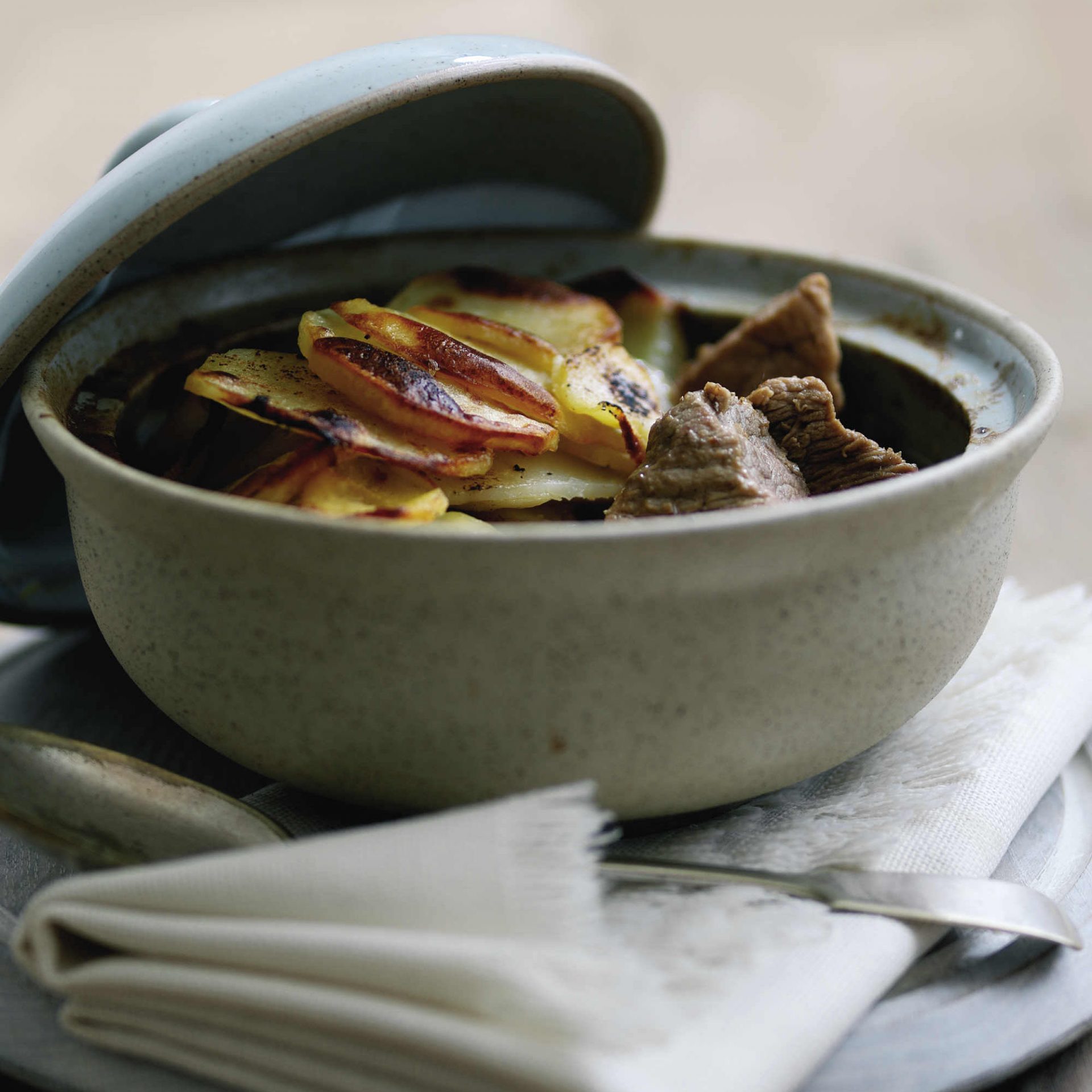 Pork hotpot served in a lidded grey casserole dish