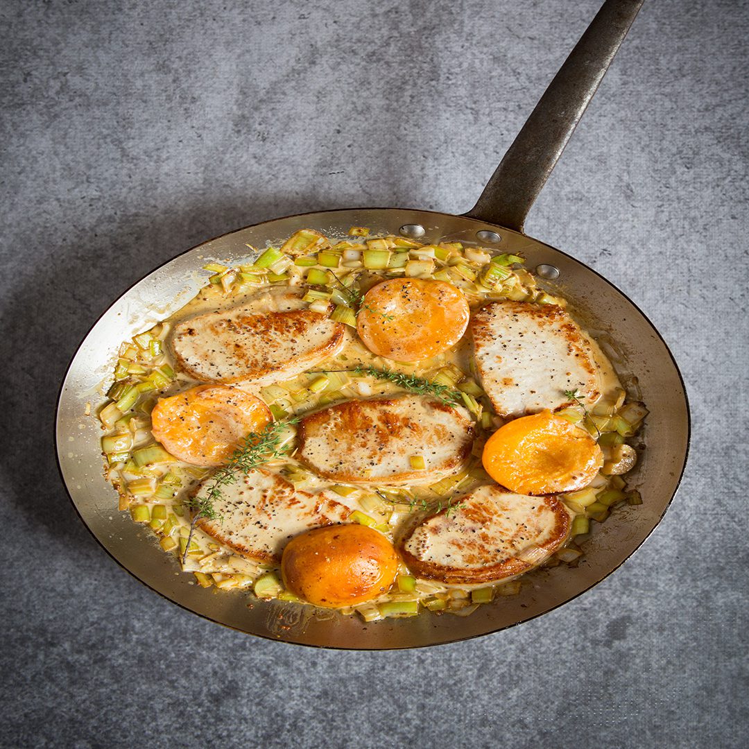 Pork medallions with an apricot and leek sauce in a large frying pan