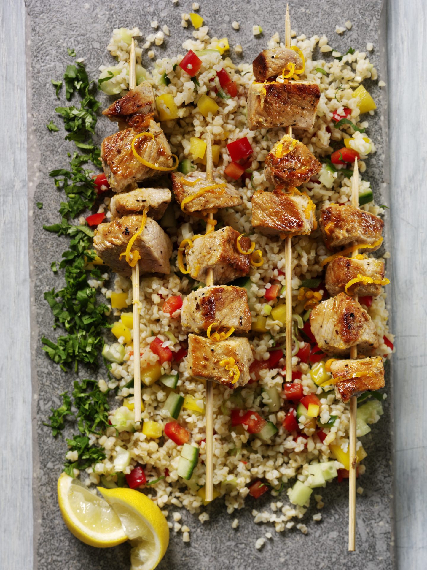 Skewered pork skewers on a bed of bulgur wheat salad