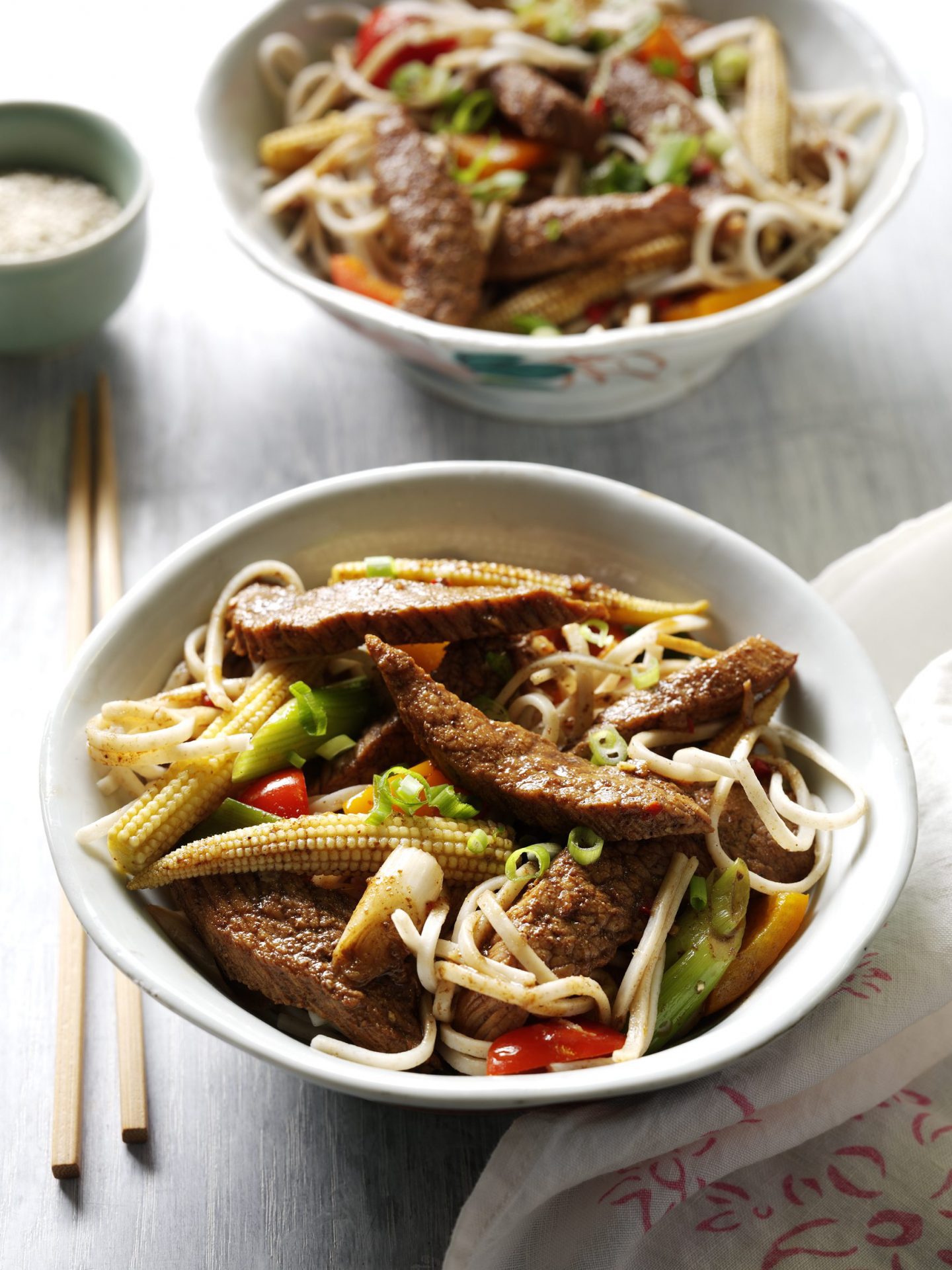 Pork stir fry with baby sweetcorn, peppers and noodles in a bowl