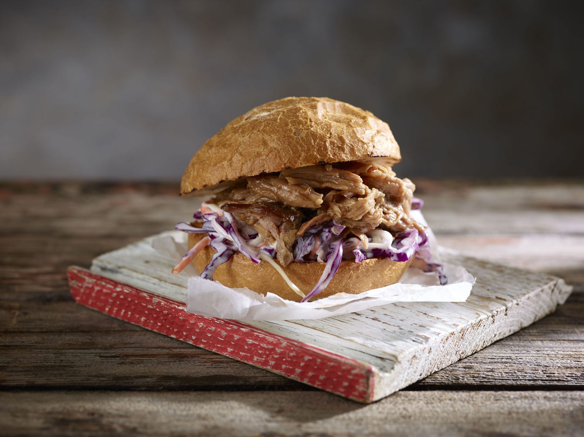 Burger bun filled with pulled pork and coleslaw