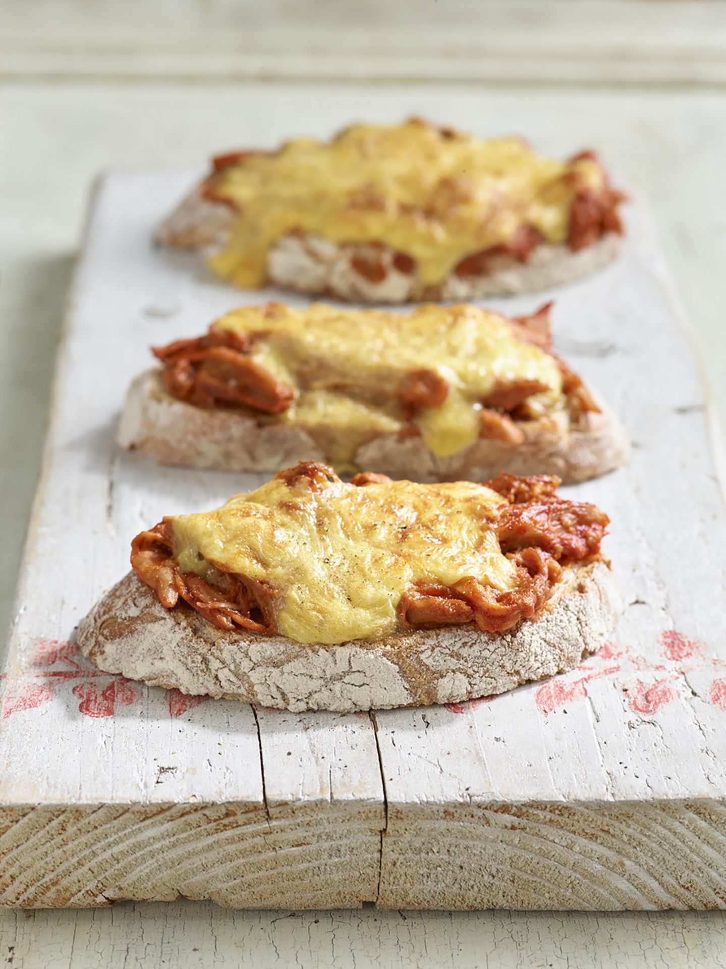 Three slices of bread topped with pulled pork rarebit