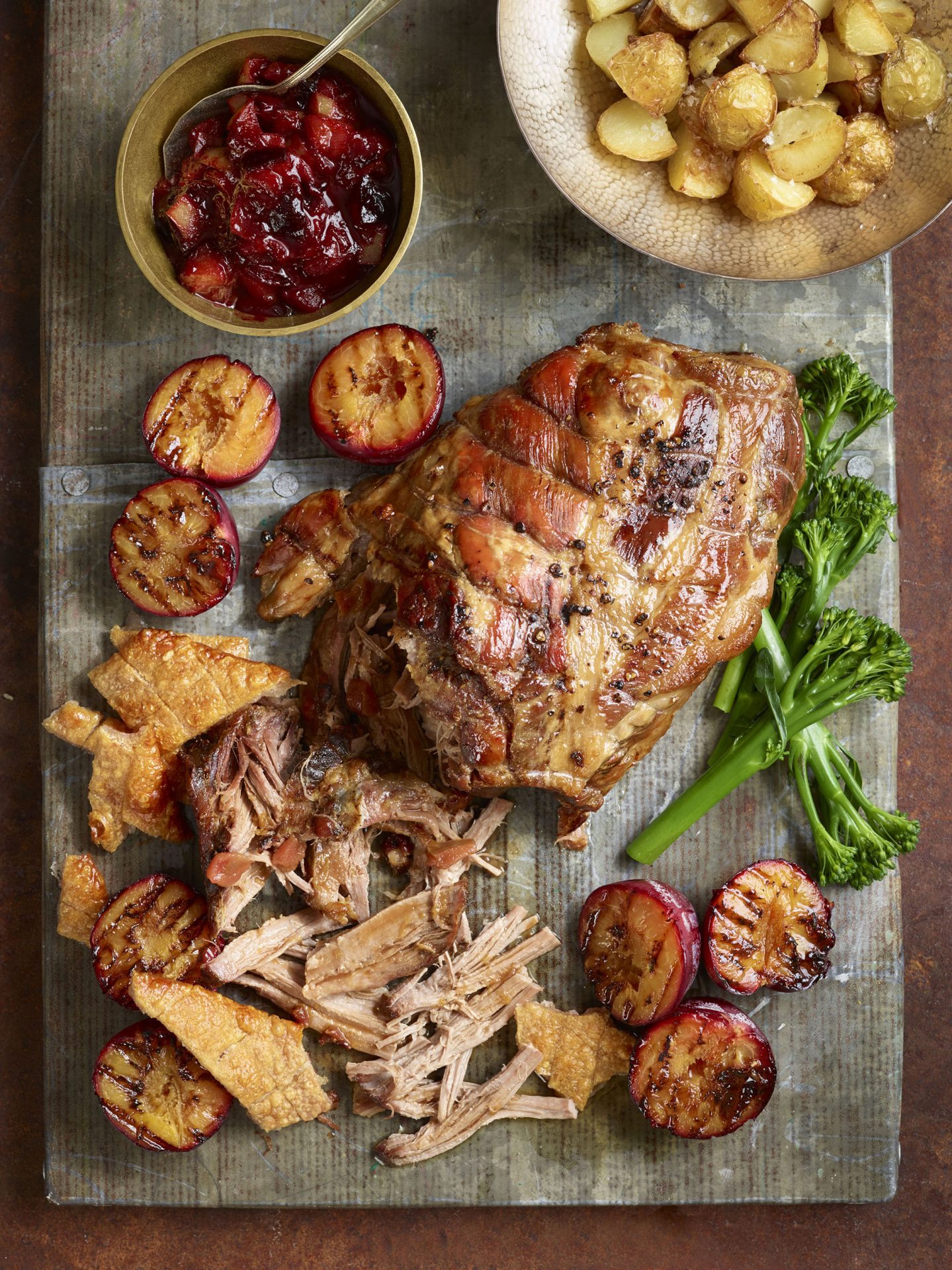 Pulled pork joint with crackling and vegetables on a serving board