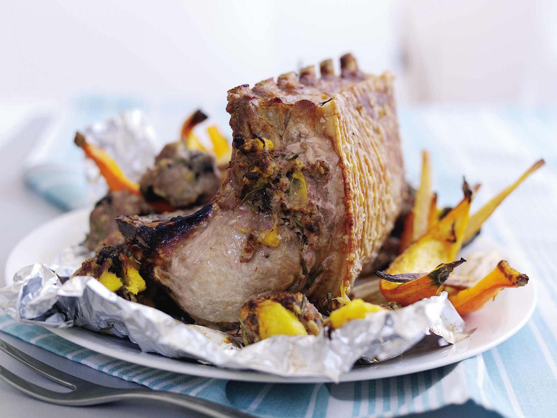 Roast pork loin served on a plate with a mango and black pudding stuffing