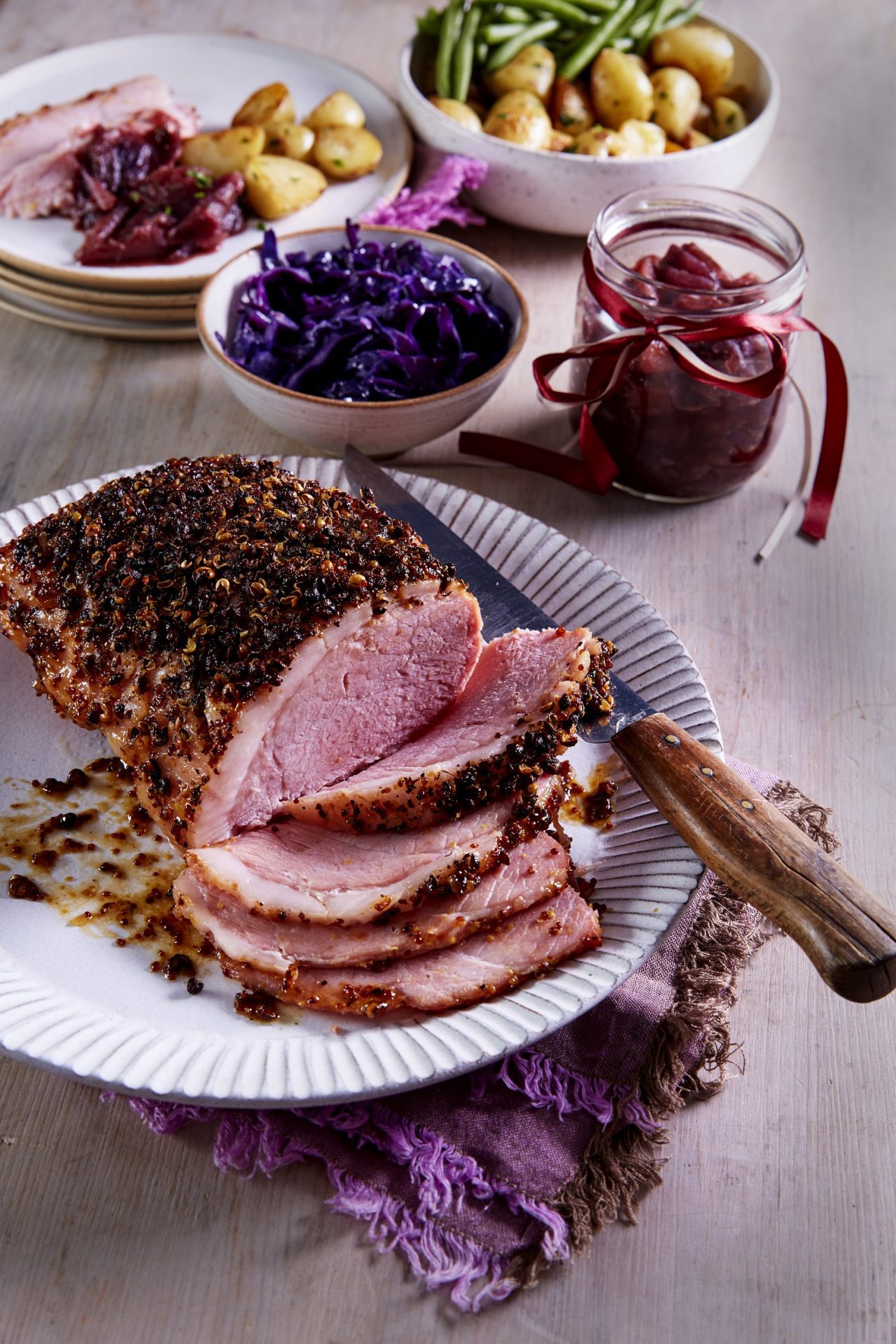 Roast gammon joint with Szechuan crust, some sliced, on a white platter