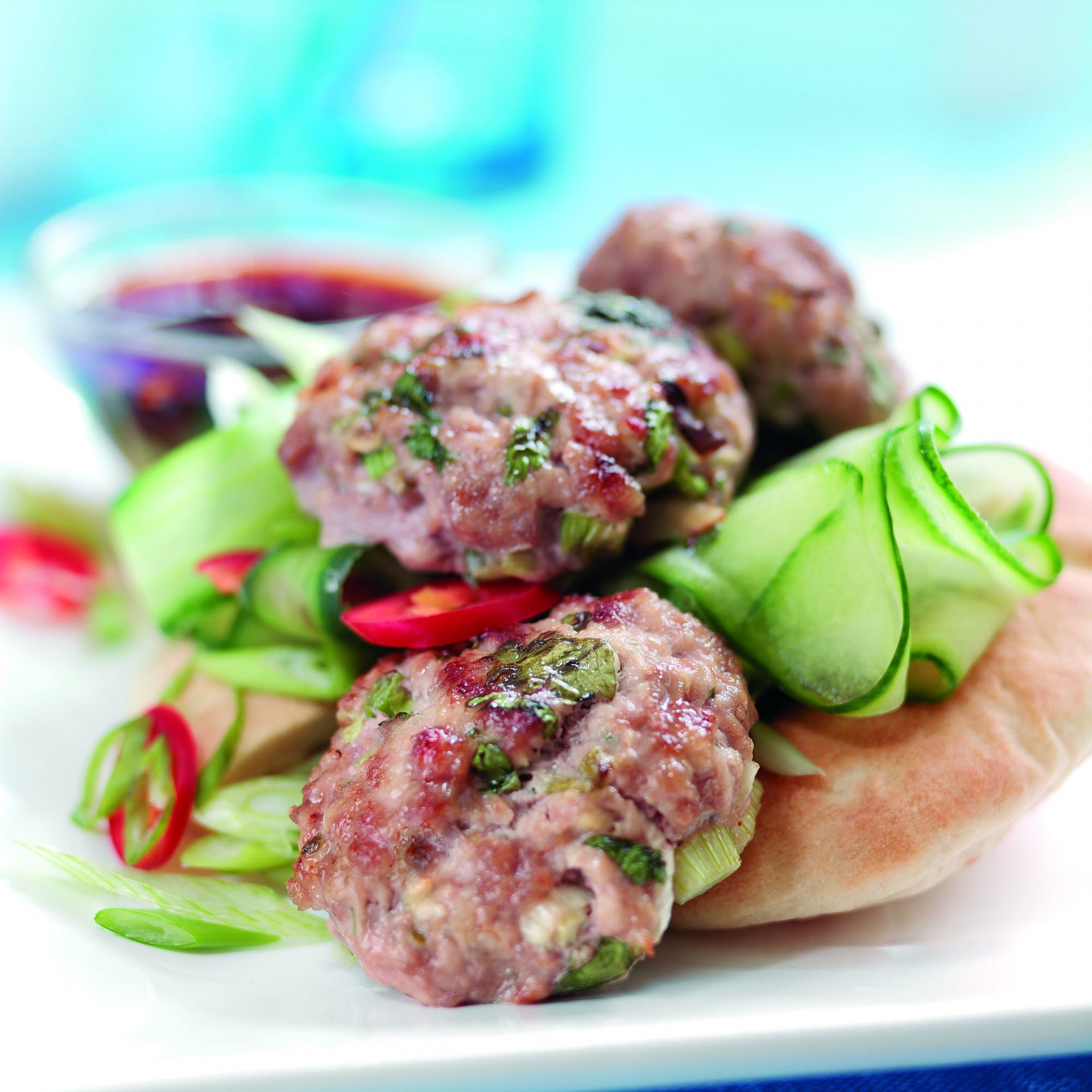 Thai pork bites with dipping sauce on a plate