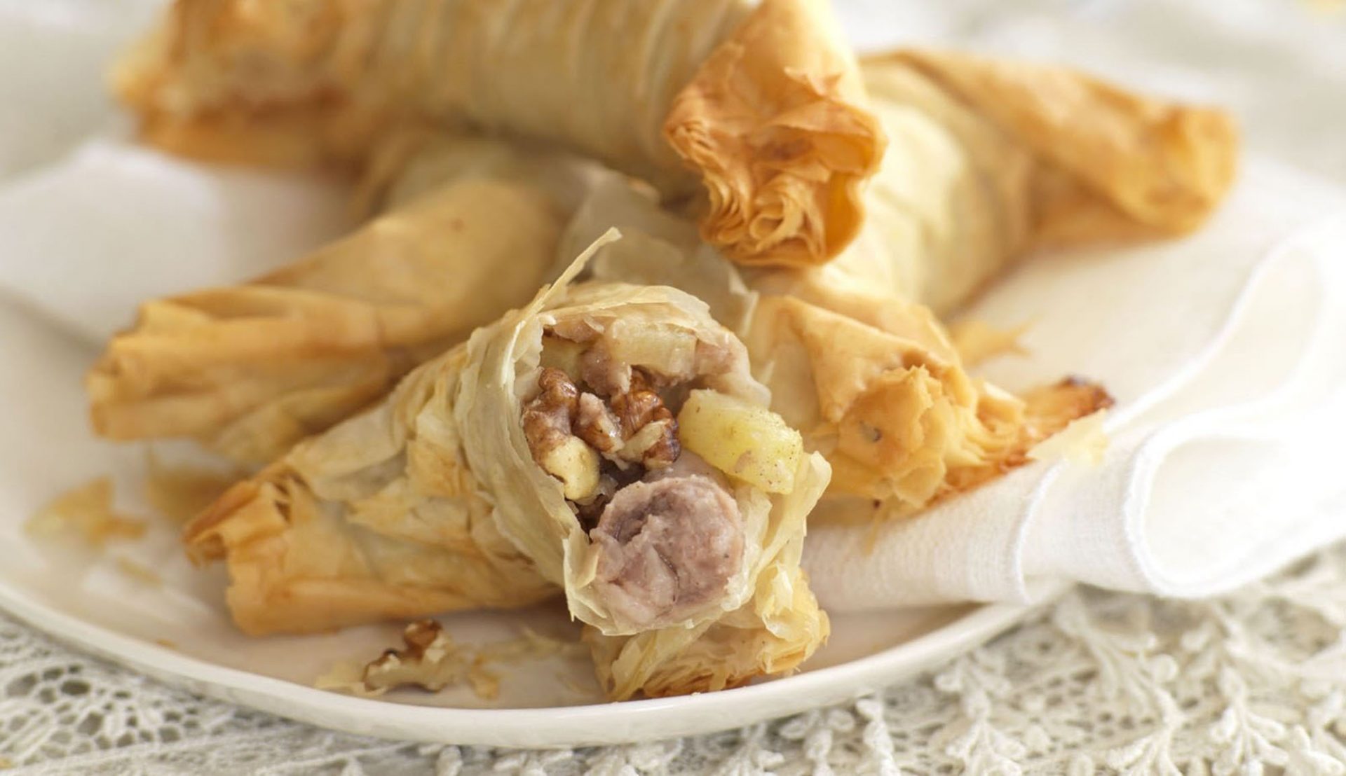 White plate filled with sausage strudel parcels