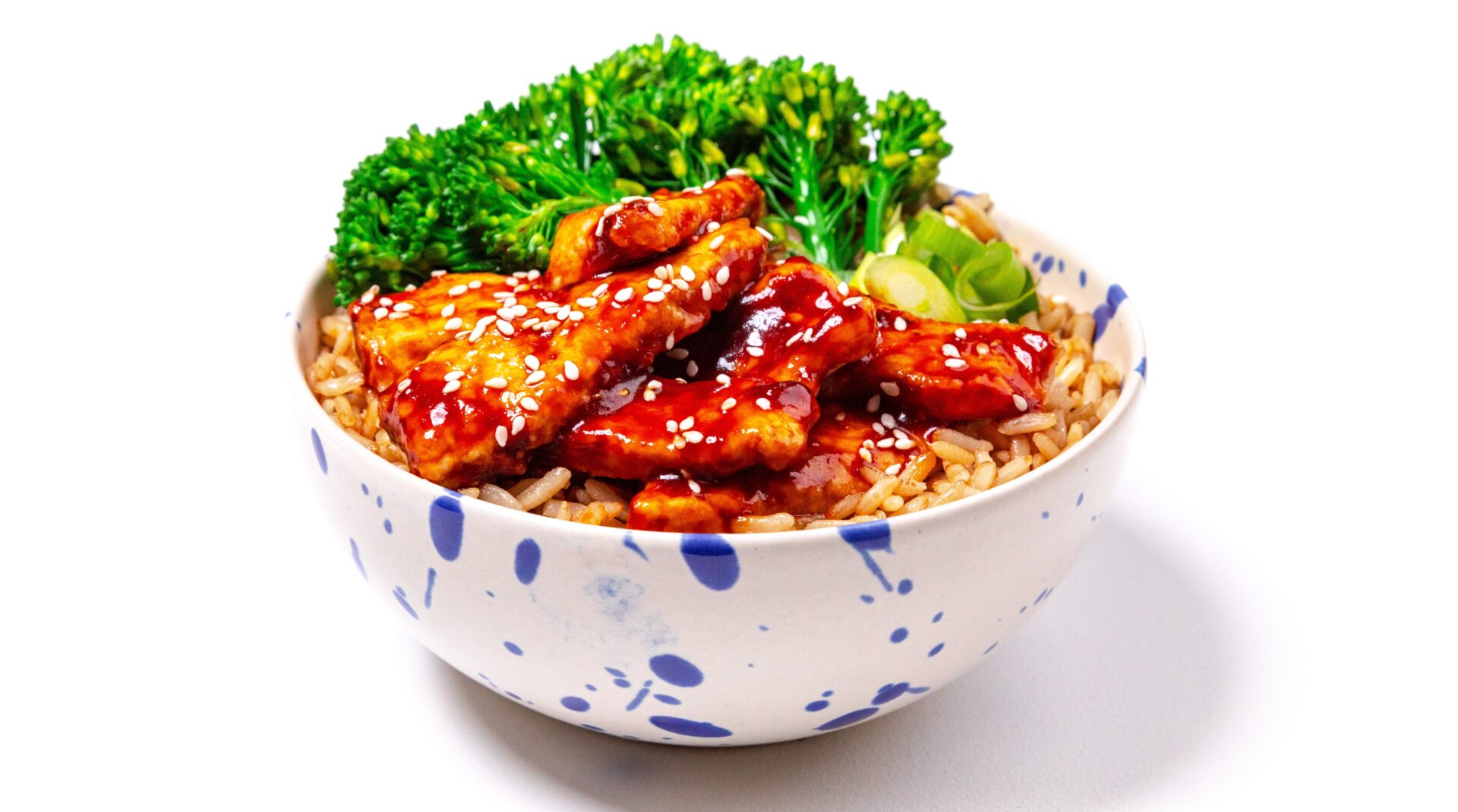 Sweet chilli pork with rice and broccoli in a blue and white spotty bowl