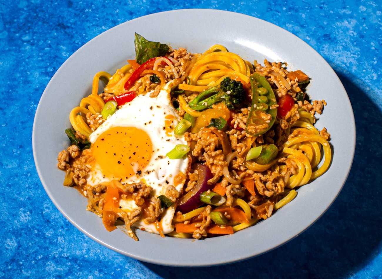 Korean Pork Mince Bowl with running fried egg in a blue bowl