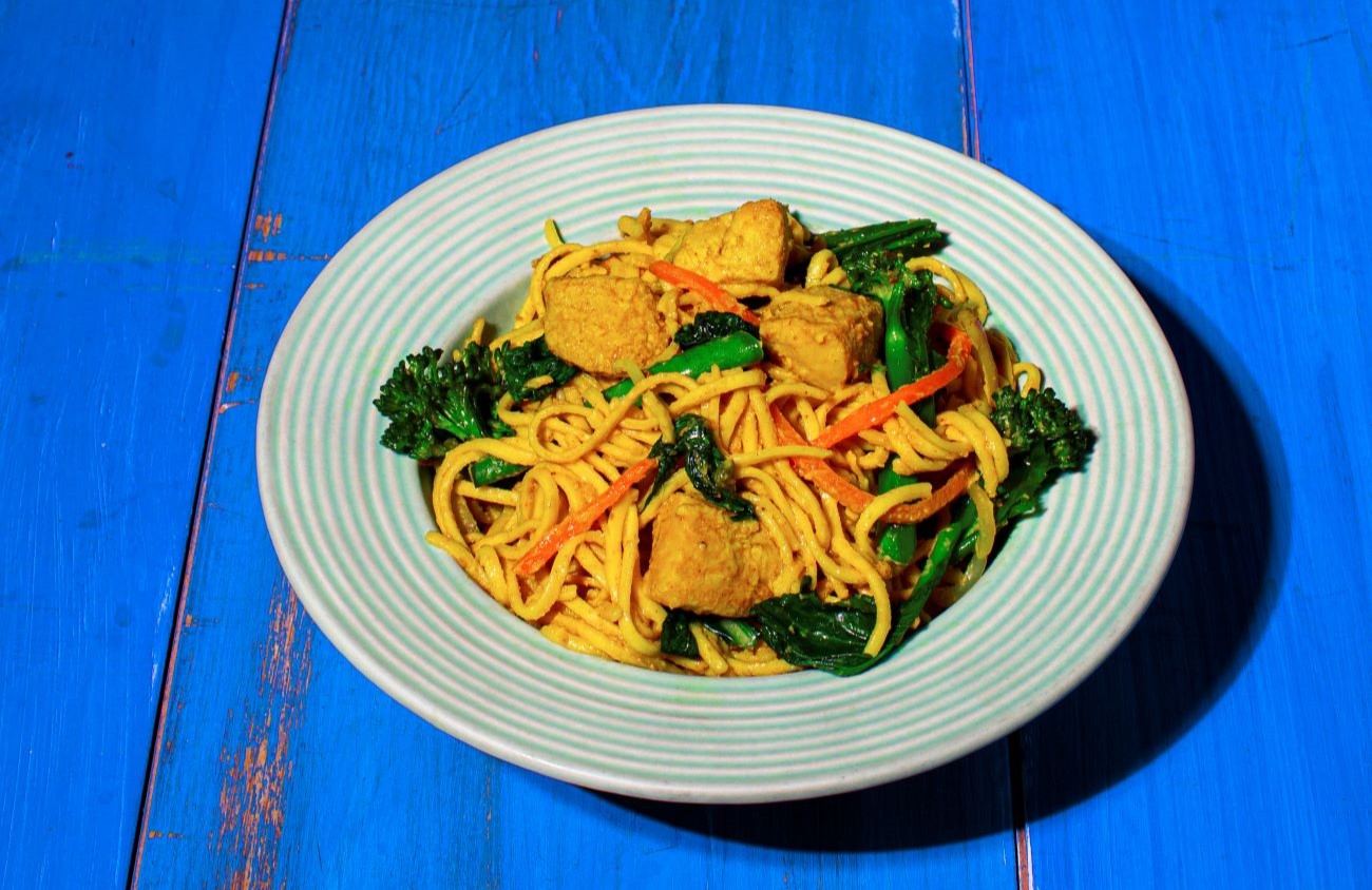 Pork Satay Noodles with vegetables served in a pale blue bowl