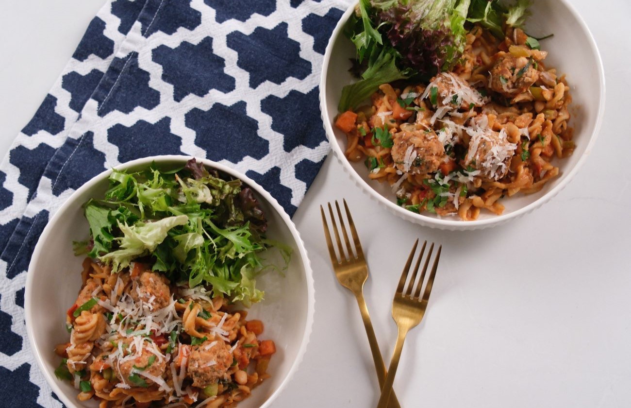 Pork Meatball and Bean Pasta served in two bowls with side salad.