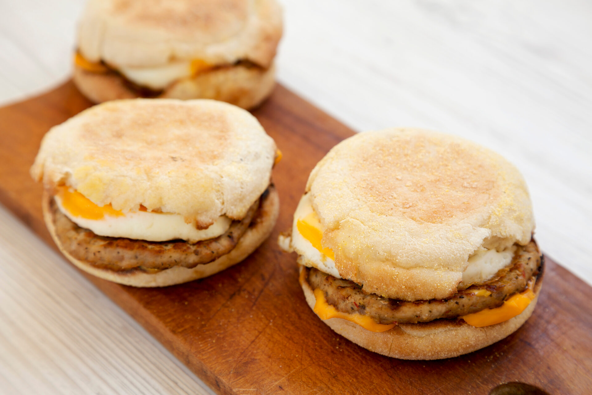 Sausage and egg McMuffins on a wooden board