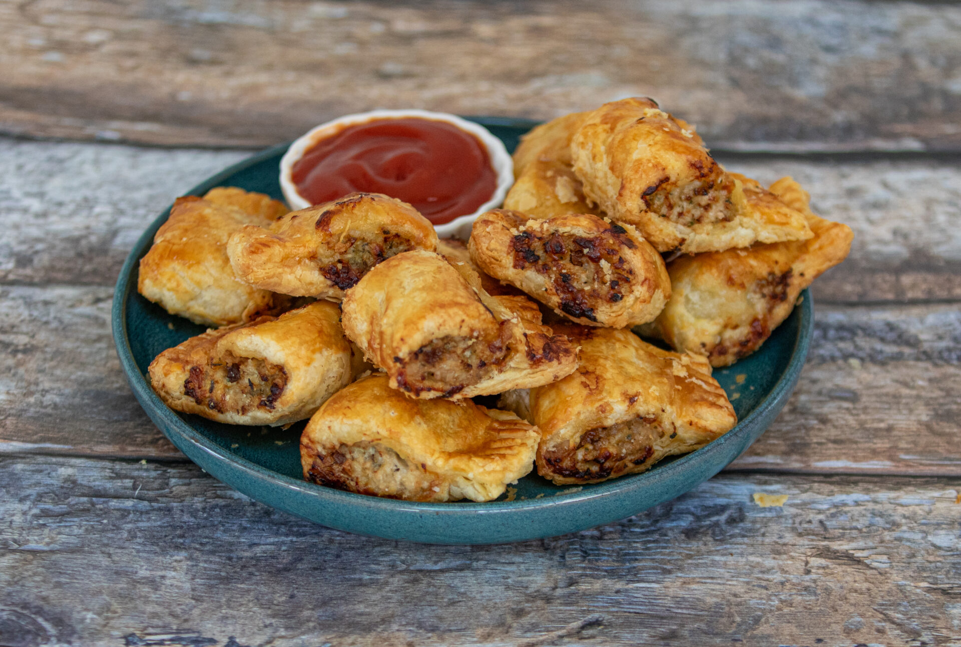 Pork, Cheese and Pickle ‘Sausage’ Rolls on a plate with ketchup