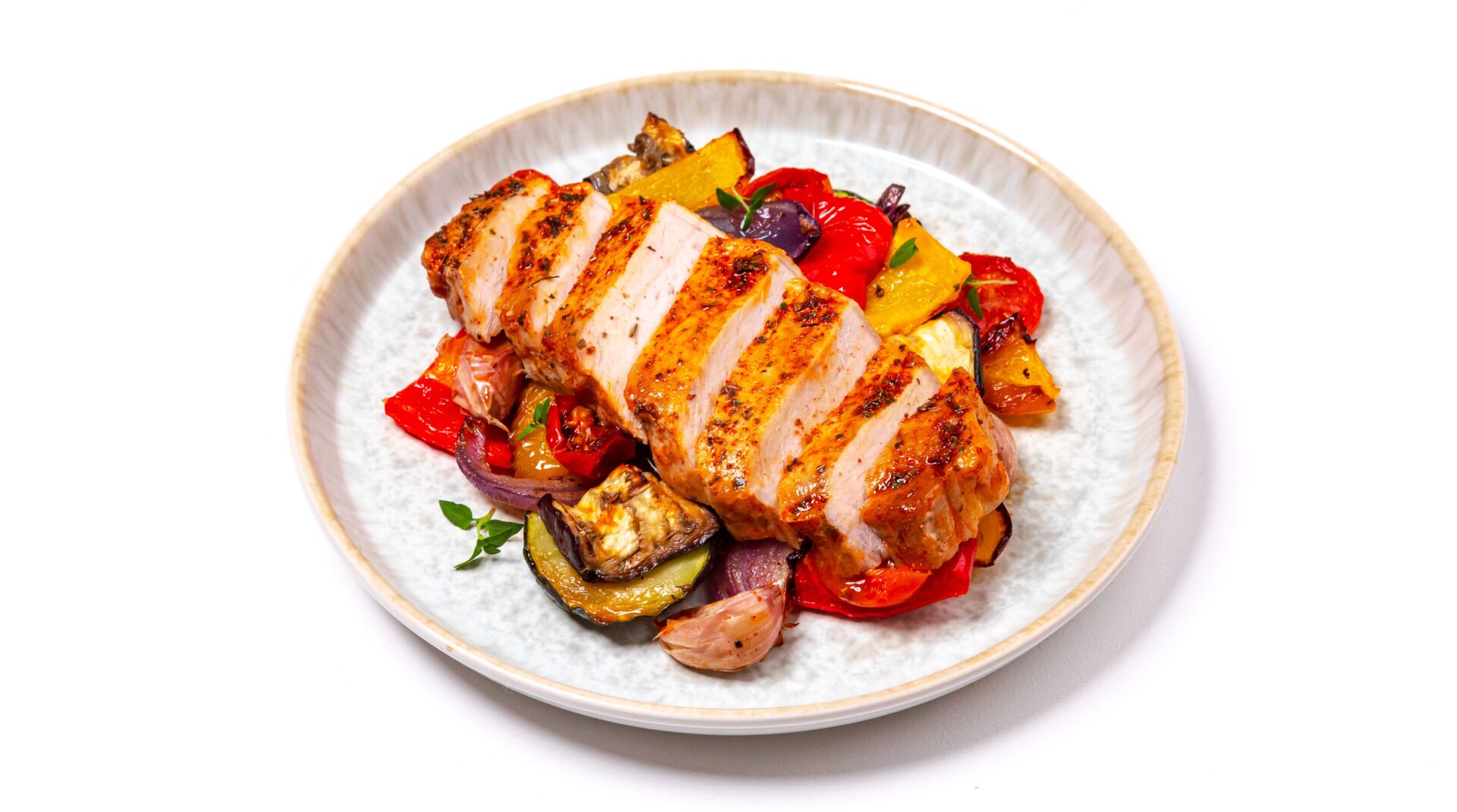 Air fried pork with roasted vegetables on a white plate