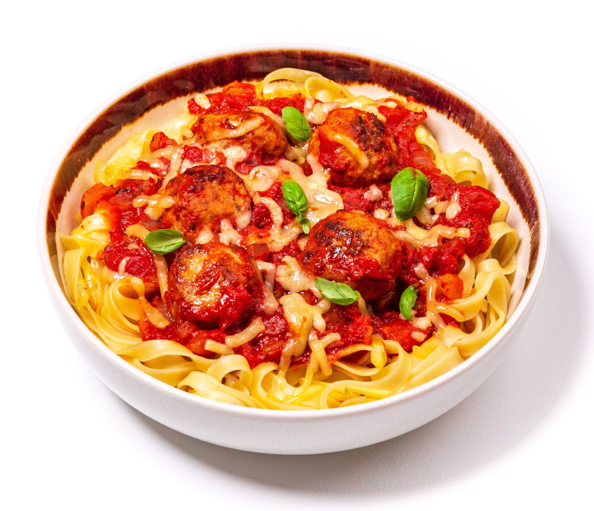 Meatballs in a tomato sauce on pasta in a white bowl