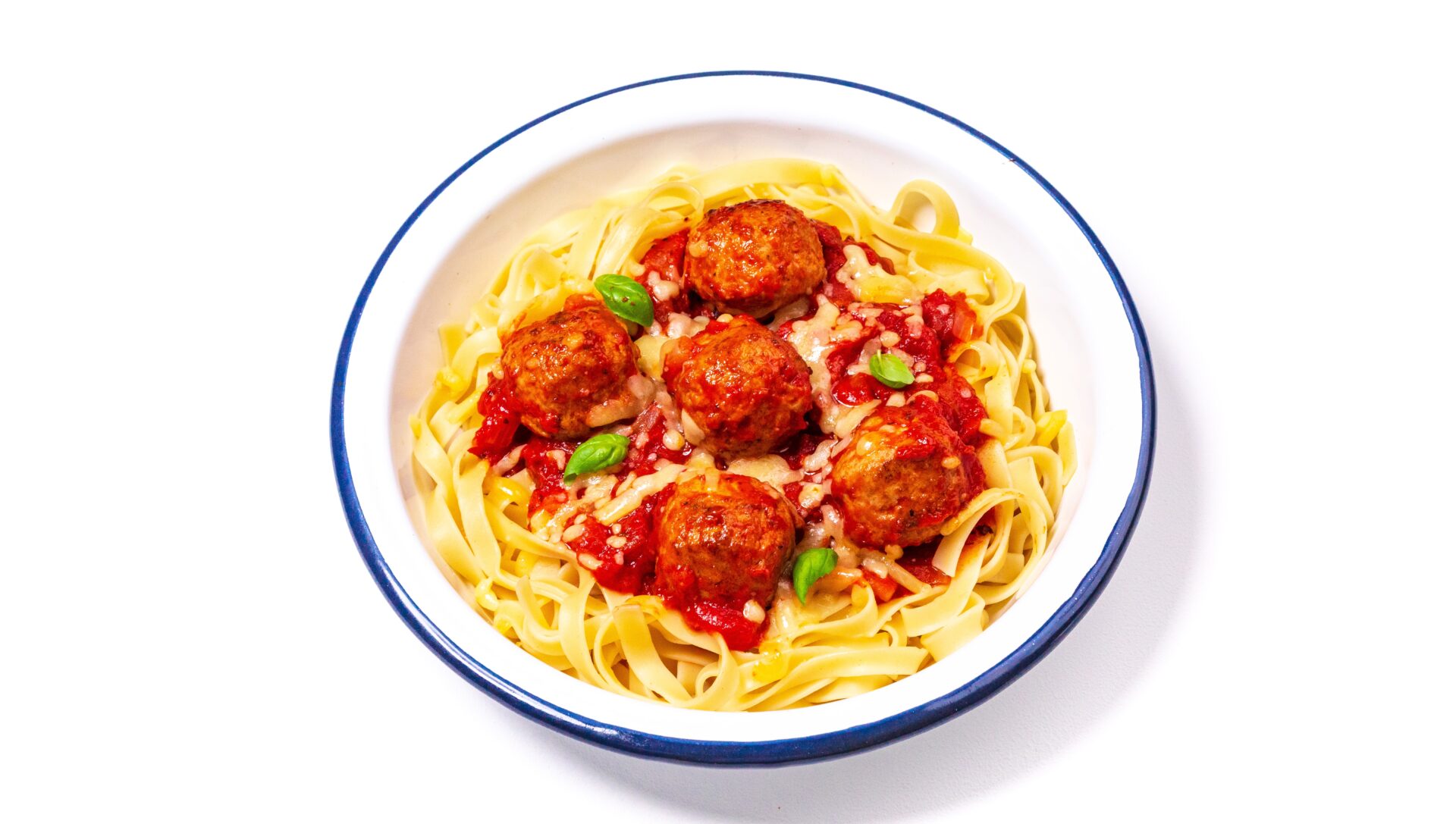 Meatballs in a tomato sauce with pasta in a white bowl with a blue rim