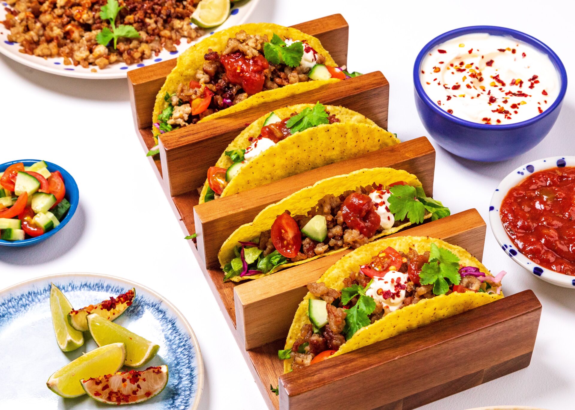 Smoky pork mince tacos with little pots of sour cream and salsa